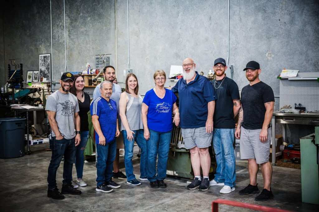 Team of letterpress printers posing in a warehouse